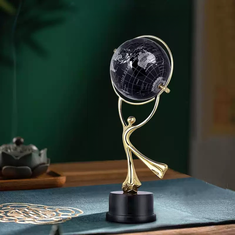 Brass globe decoration on black base held by figure—elegant room decoration, birthday gift, housewarming gift décor