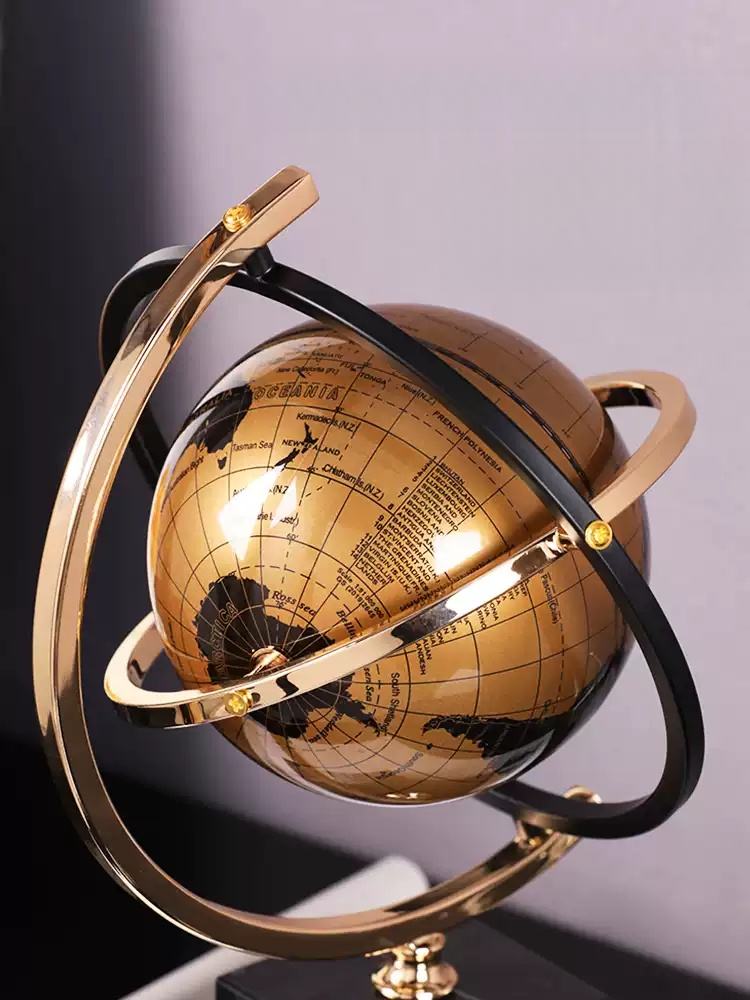 Close-up of gold globe decoration showing metal rings and map details for room decoration